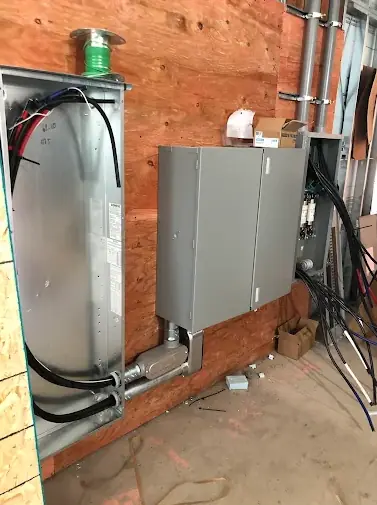 Plywood backboard with a wireway, a disconnect switch and conduit during a commercial rough-in